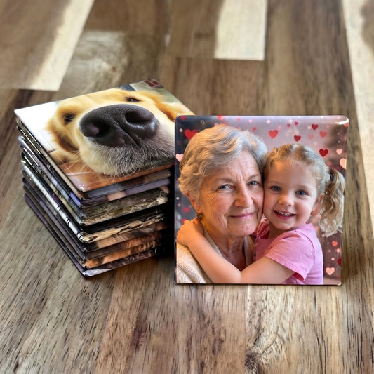 12-Magnet Photo Set — twelve custom 2-inch photo magnets arranged on a wood surface showing varied family memories