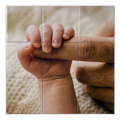 Photo mosaic magnet in a 3x3 square grid showing a baby hand holding onto a grandparents finger